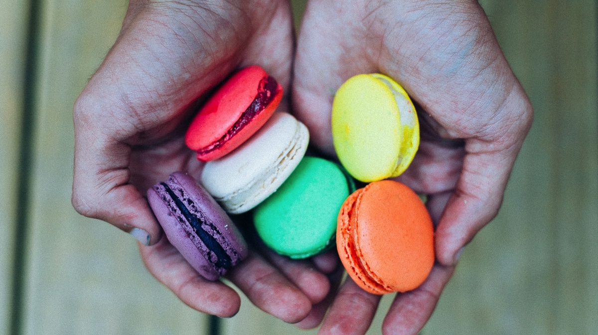 Close-up of hands holding colorful macaroons