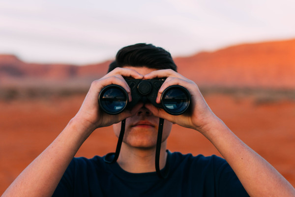 A man looking through binoculars.