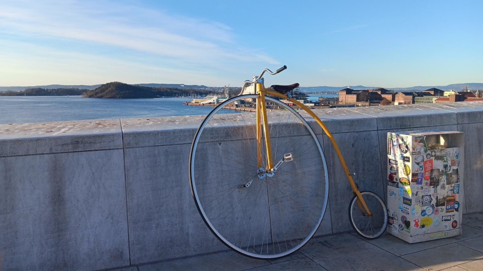 Picture of an ordinary bicycling leaning against a stone wall overlooking Oslo fjord.