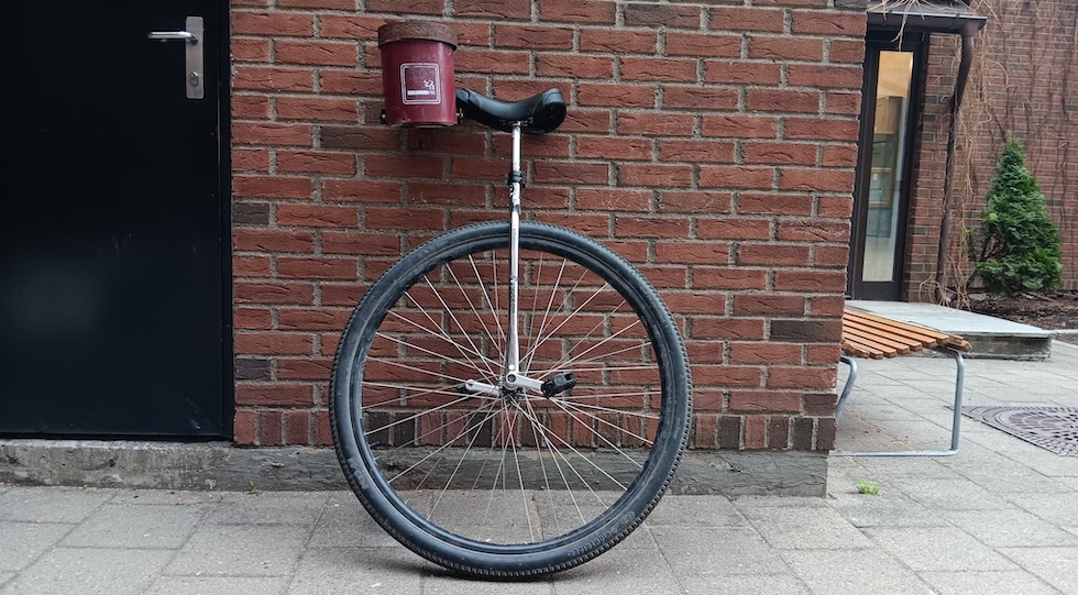 36 inch wheeled unicycle, leaning n a brick wall.