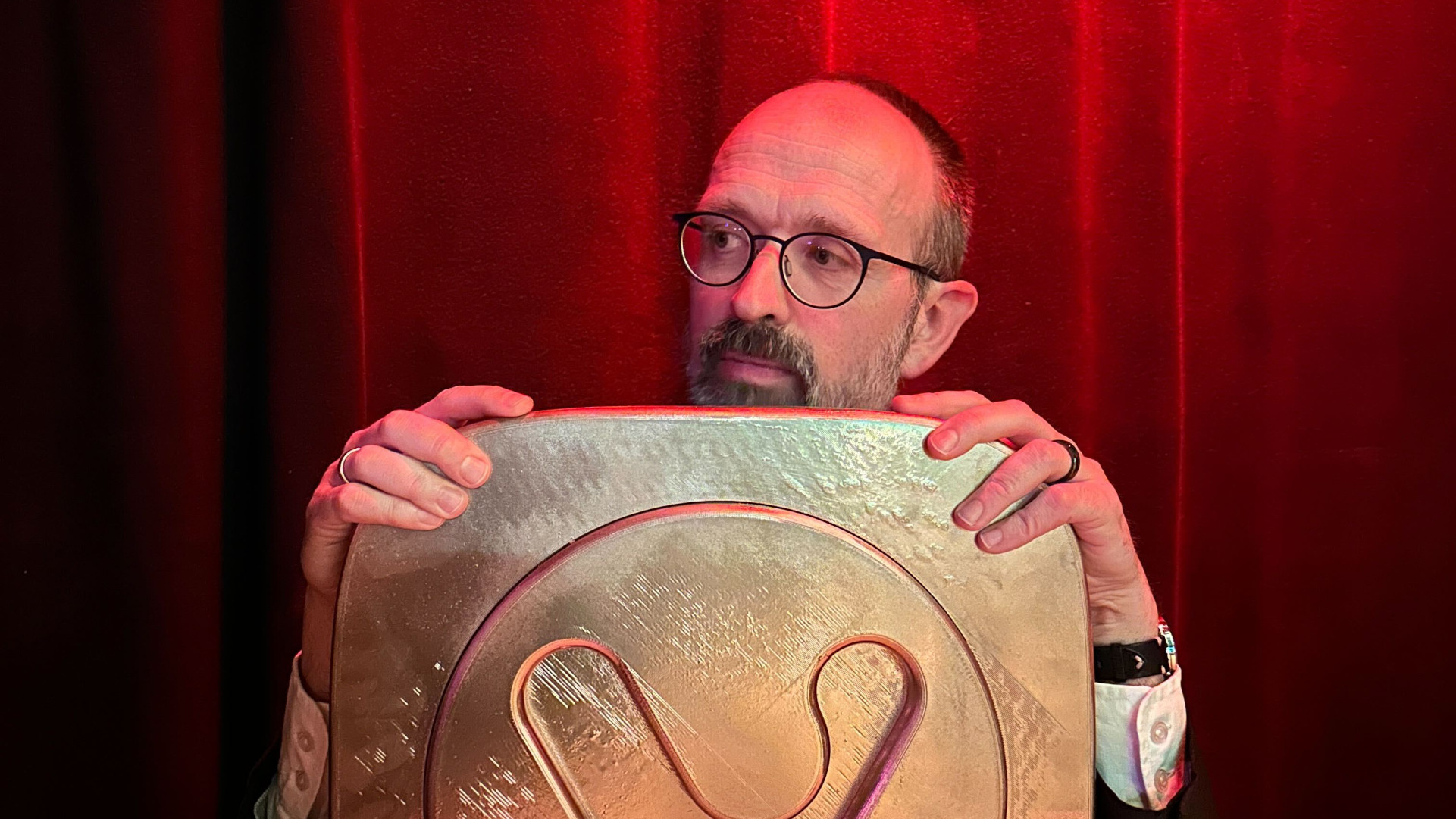 Man holding a large, golden Vivaldi logo