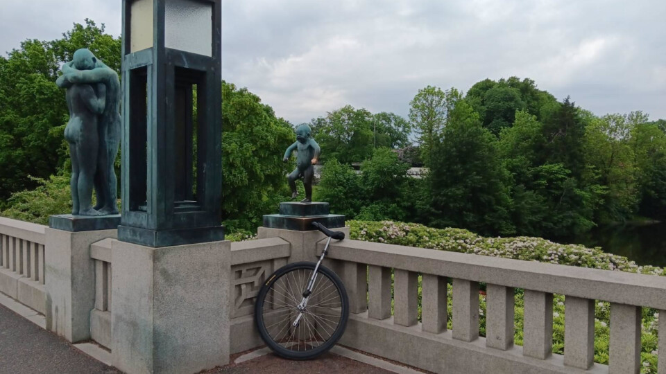Sinnataggen (The Angry Boy) shows a naked, chubby little boy clenching his fists, raising his shoulders and right leg, and screaming in anger while standing on one foot. In front of him is a large wheeled unicycle.