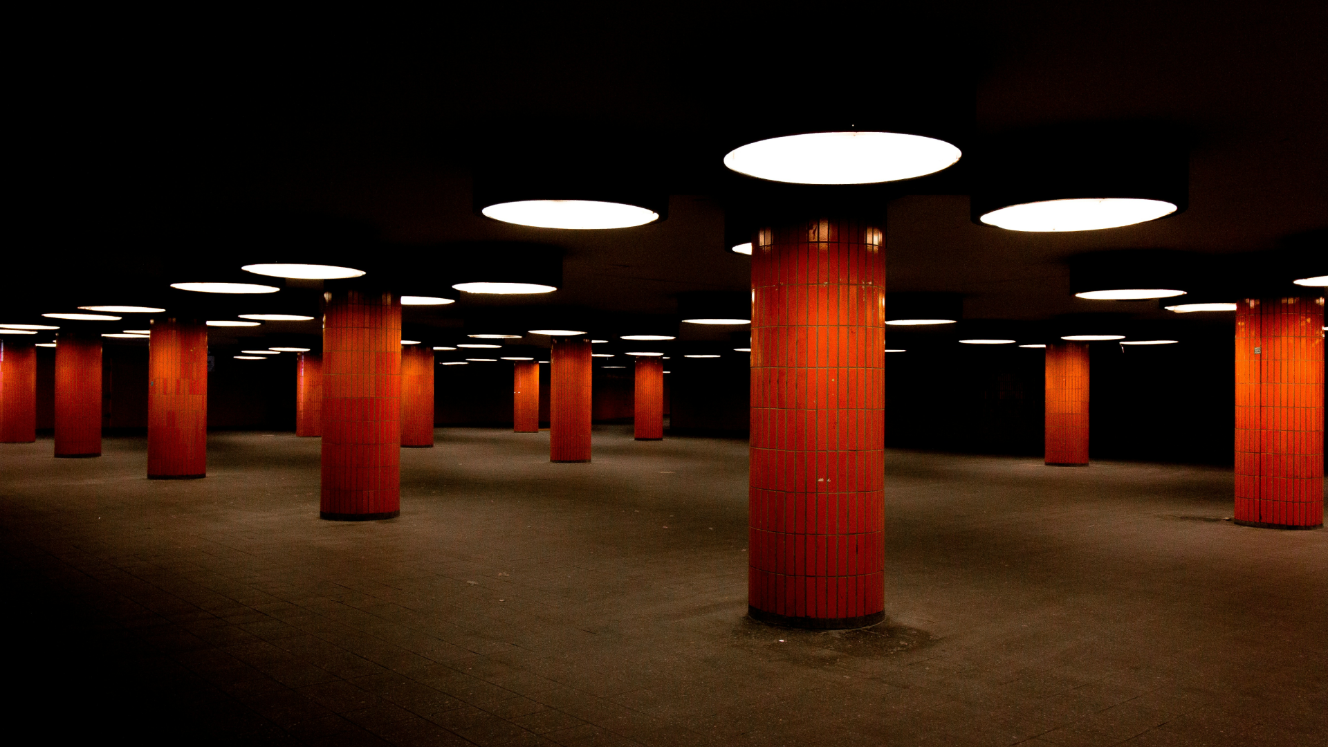A dark underpass with orange columns.