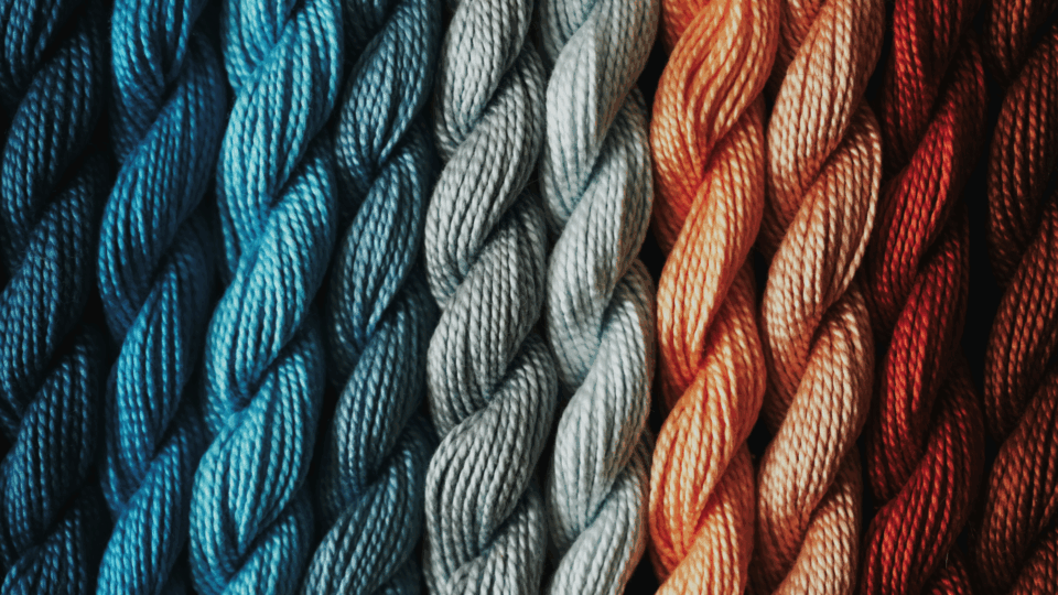 A close up of a bunch of yarn in different colors.
