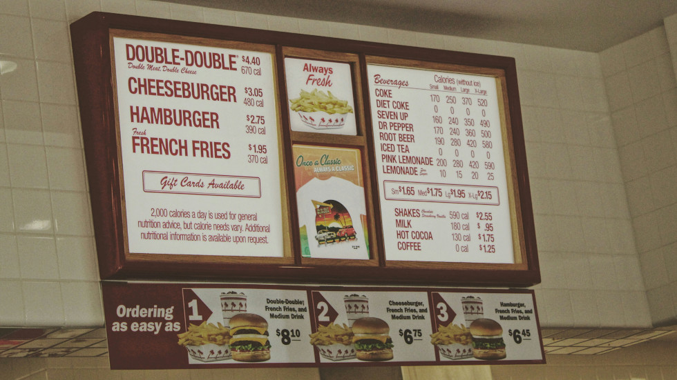 The wall mounted menu from a burger restaurant.