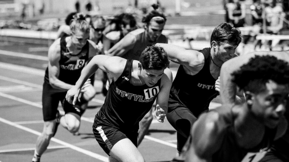A close up of competitive runners. The image is in back and white.