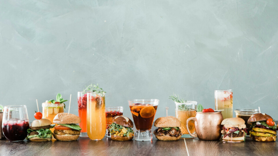 A bunch of different cocktail like drinks and hamburgers in a row.