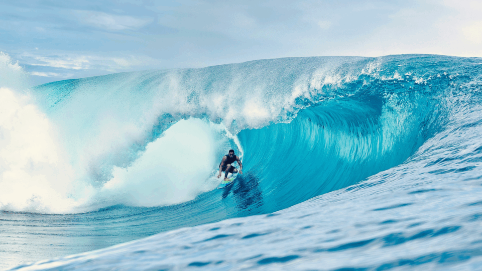 A man riding a wave on top of a surfboard.