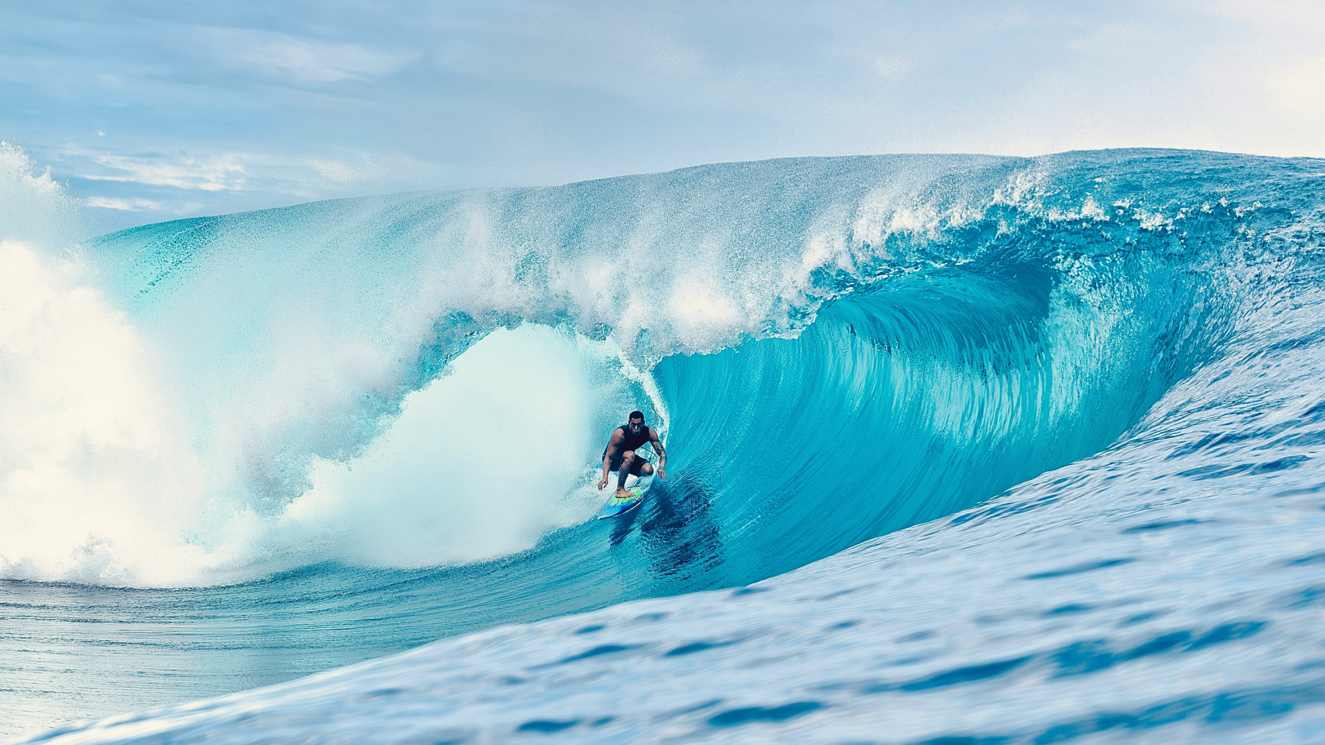 A man riding a wave on top of a surfboard.