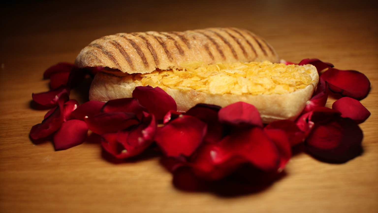 Crushed crisps in a panini, on a bed of petals