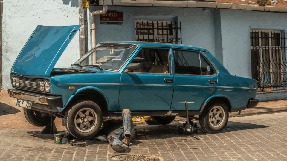 Man repairing his vintage car in the street.