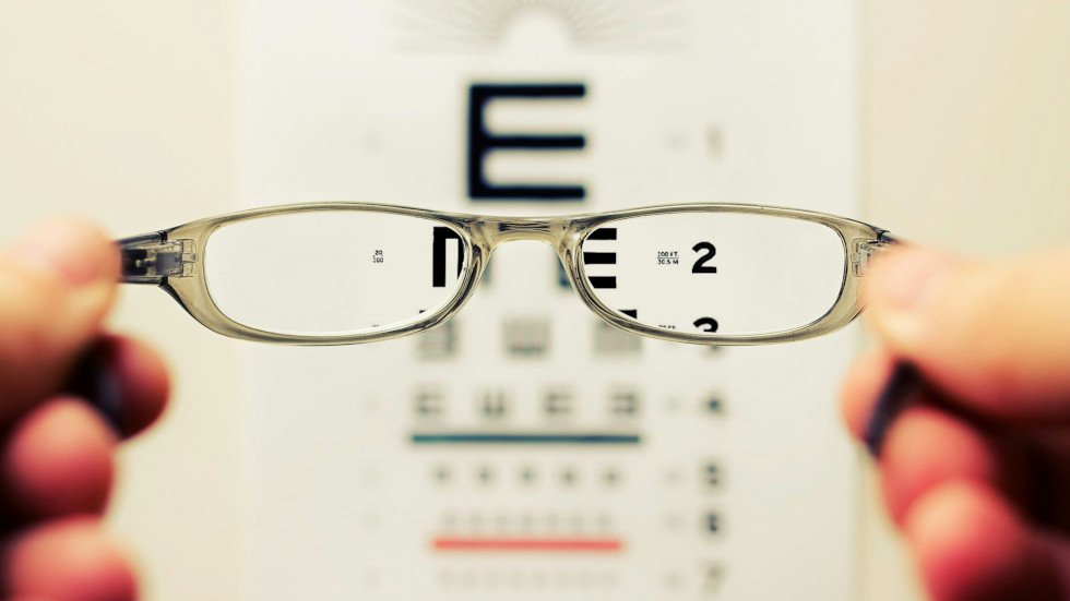 Some glasses held in front of an eye test thus making it more readable