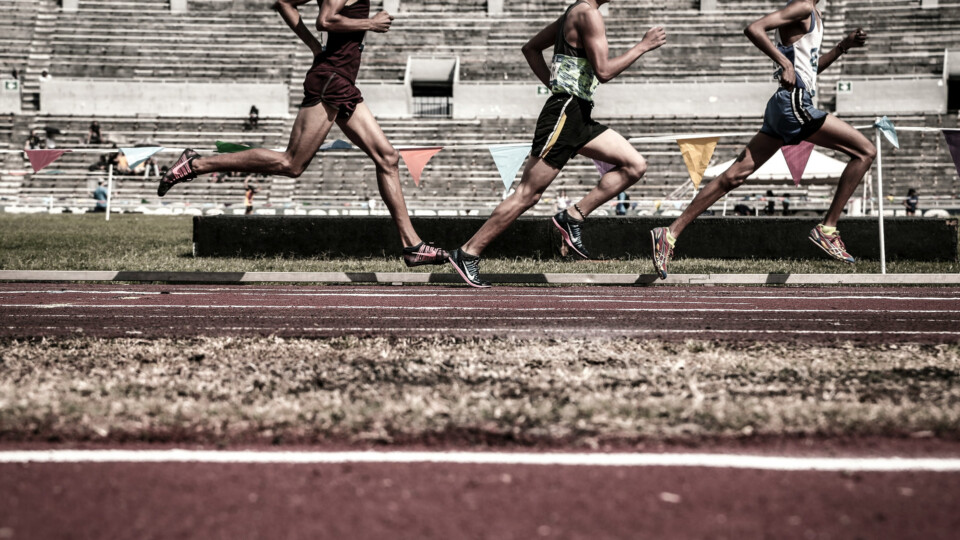 Runners on a running track. The top of the image clips their heads off so that you cannot see who they are