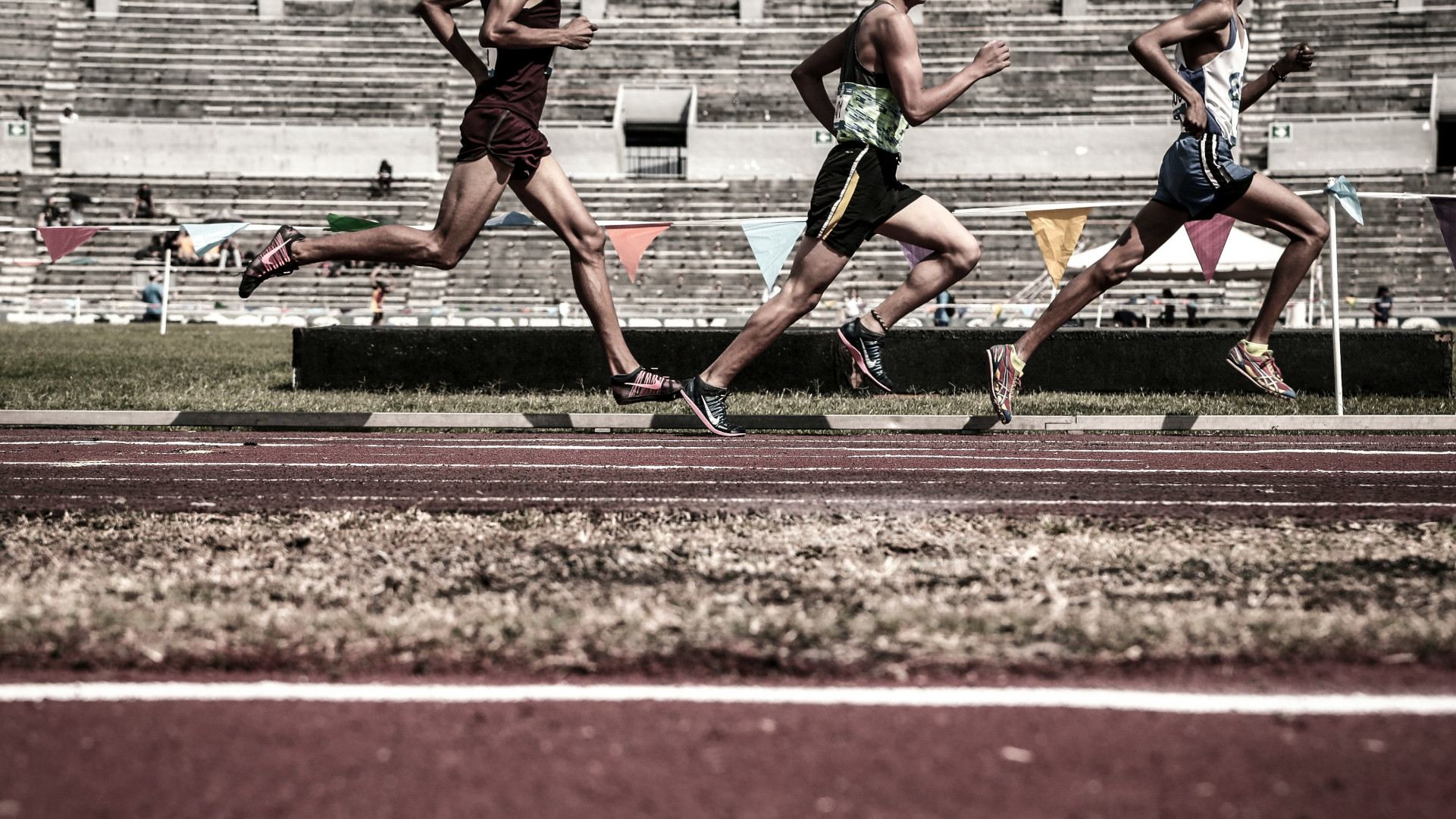 Runners on a running track. The top of the image clips their heads off so that you cannot see who they are