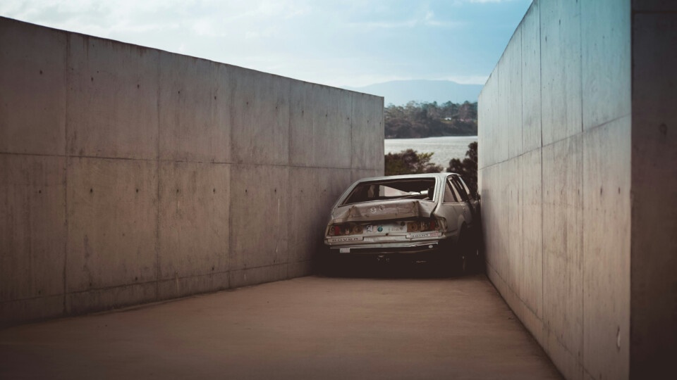 Car that is broken from trying to drive through a small gap.