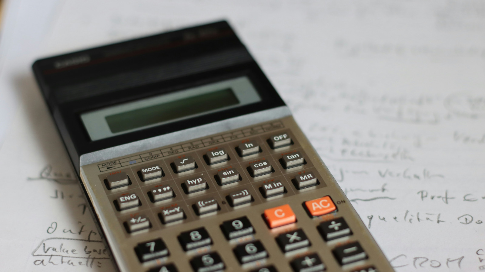 Scientific calculator resting on handwritten math notes