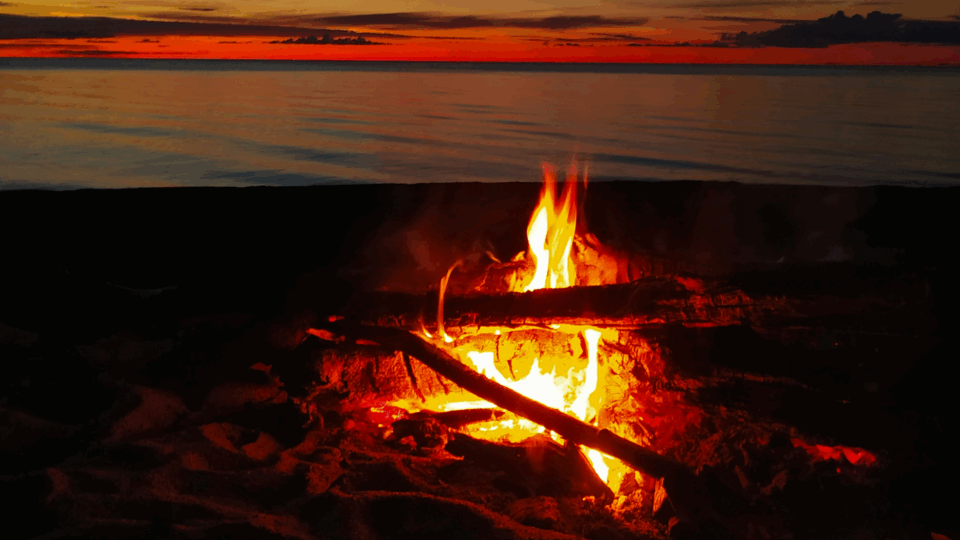 Bonfire on a beach at sunset.
