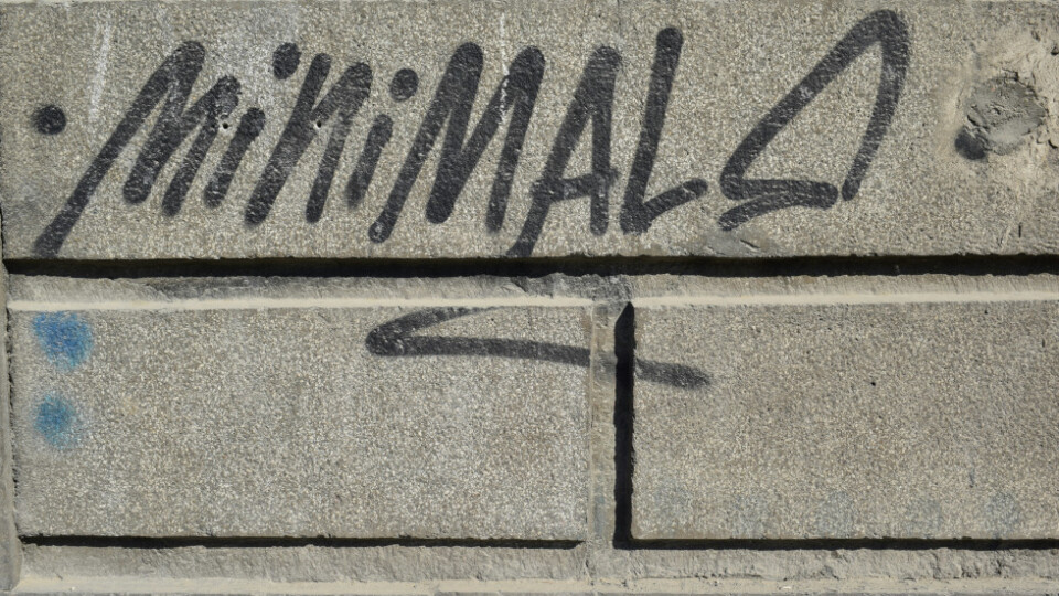 A wall with graffiti that says: minimal