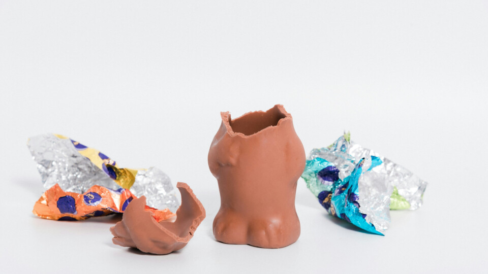 A half eaten Easter cholocate bunny, with packaging laying on either side.