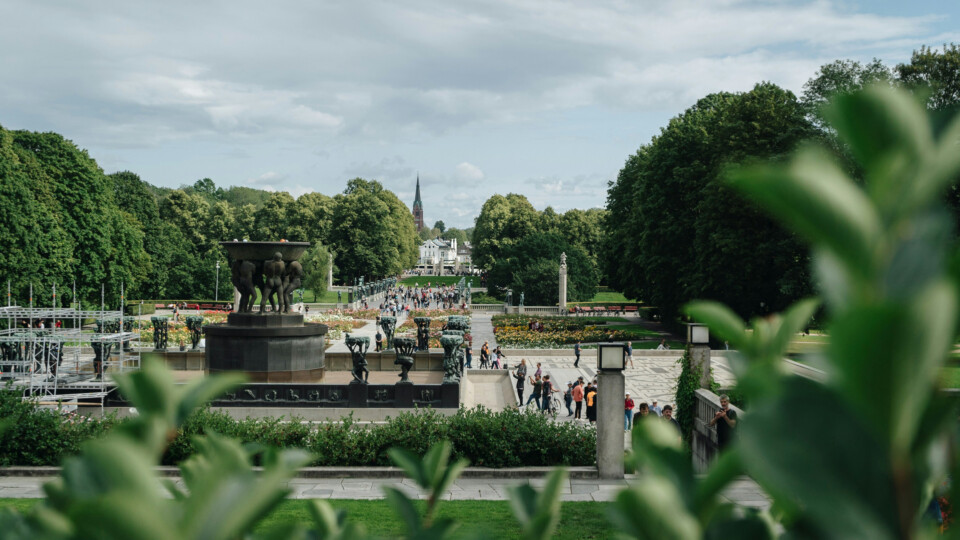 View over Frogner Park’s Vigeland installation in Oslo, showing the central fountain, surrounding sculptures, and visitors walking along the main axis.