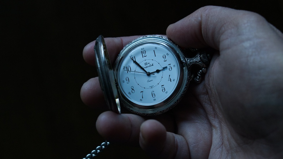 a man's hand holding a pcket watch