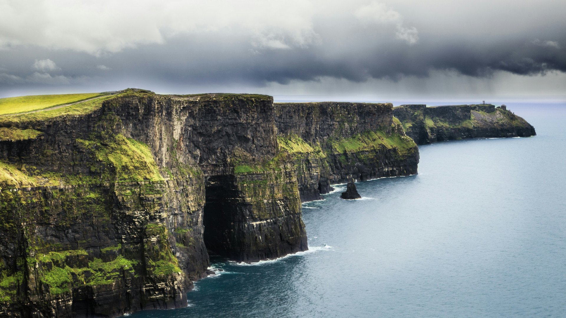 Steep green cliffs overlooking a stormy Atlantic ocean