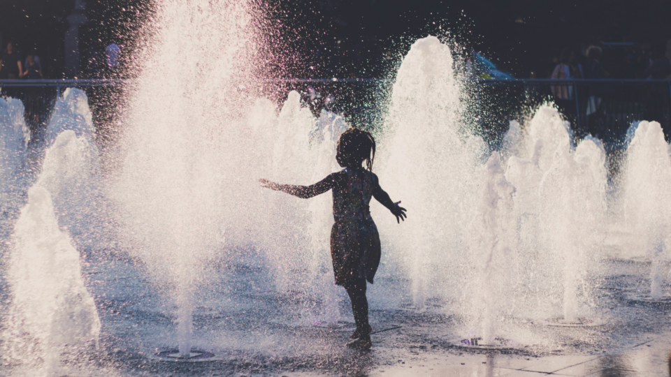 Child playing in the water fountain.