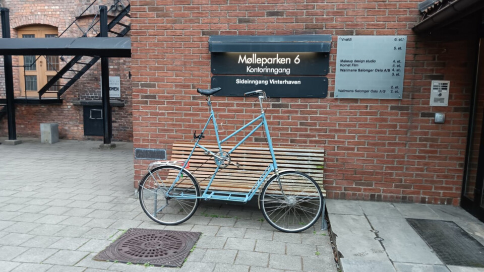 A blue tallbike in front of a sign that reads Møllerparken 6. There is a reference to Vivaldi on another sign to the right of that