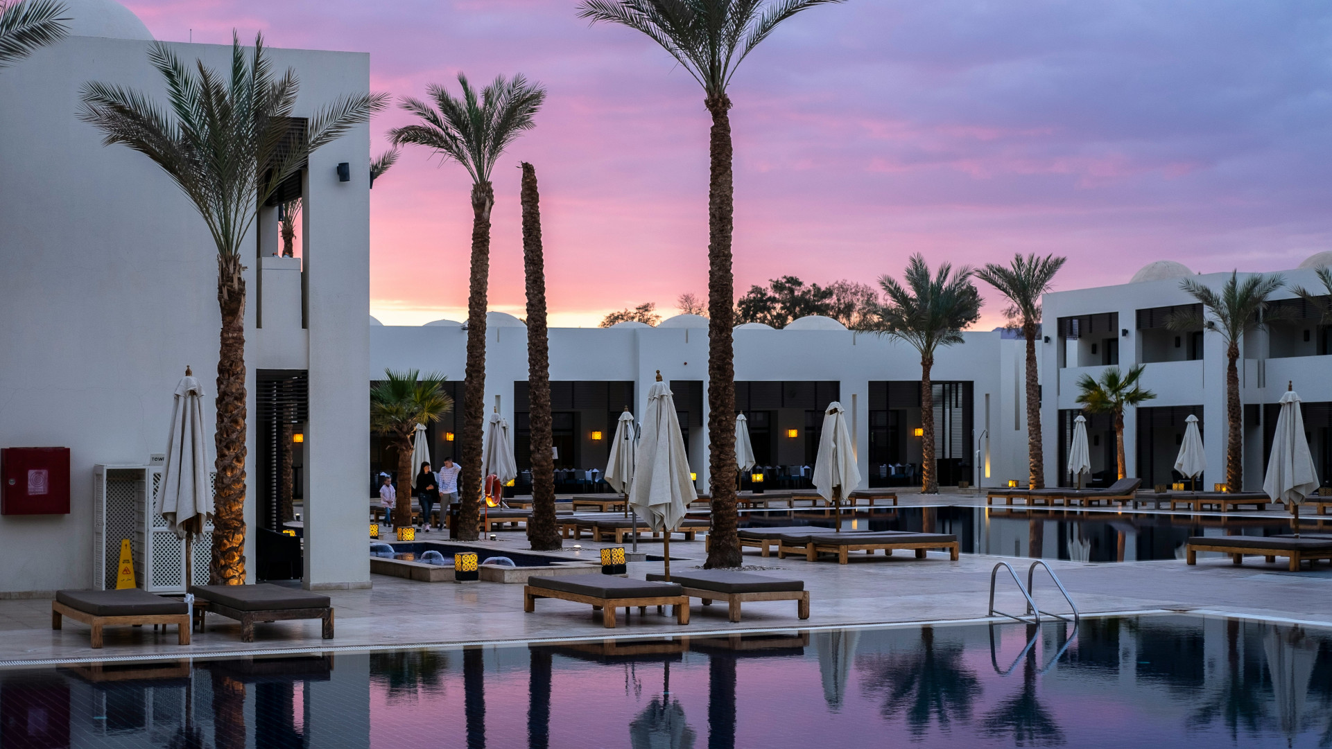 Fancy hotel with pool at sunset